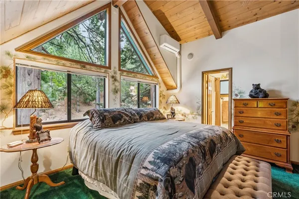 a bedroom with a bed and a large mirror next to a window