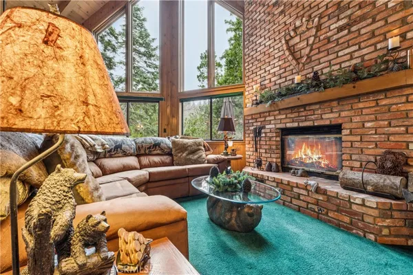 a living room with furniture a fireplace and a large window