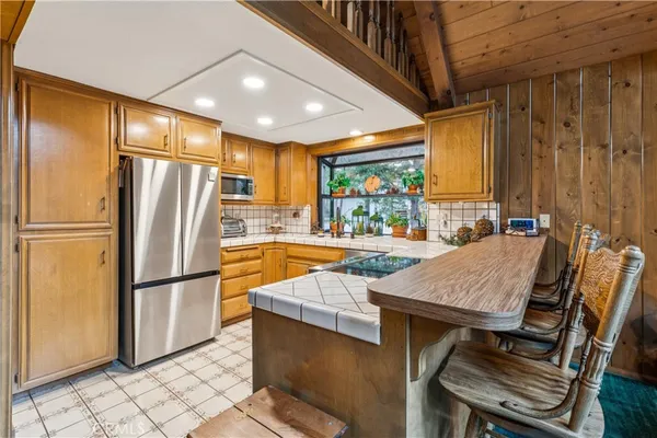 a kitchen with stainless steel appliances granite countertop a refrigerator a sink and a stove