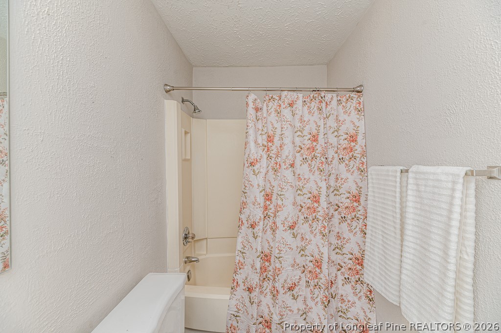 6553 Grist Mill Road Fayetteville, NC 28314 - Photo 21 of 31 a bathroom with a shower curtain and a toilet