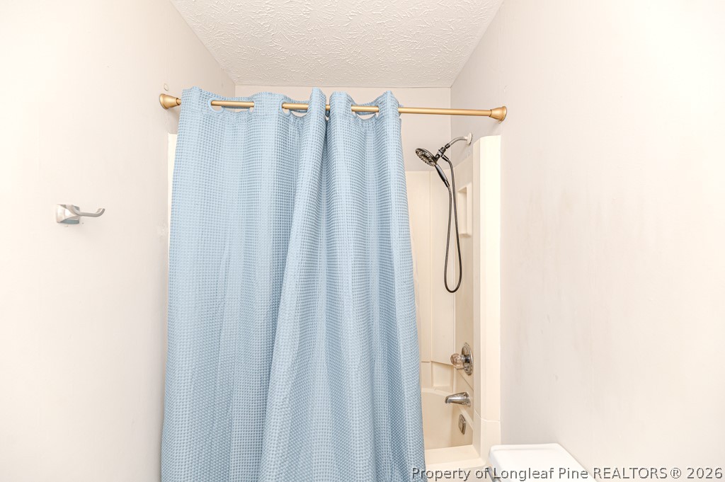 6553 Grist Mill Road Fayetteville, NC 28314 - Photo 27 of 31 a bathroom with a shower curtain and a sink