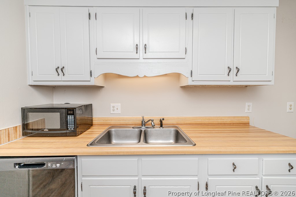 6553 Grist Mill Road Fayetteville, NC 28314 - Photo 6 of 31 a kitchen with white cabinets and a sink