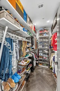 a view of walk in closet with clothes