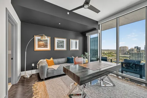 a living room with furniture and a floor to ceiling window