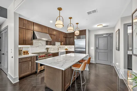 a kitchen with granite countertop a table chairs stove and refrigerator