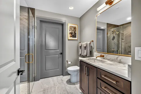 a bathroom with a granite countertop sink toilet and shower