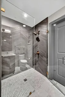 a bathroom with a shower toilet and sink