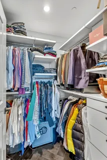 a view of walk in closet with clothes
