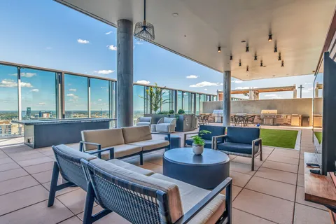a living room with patio furniture and a floor to ceiling window