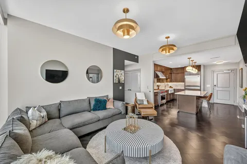 a living room with couches and kitchen view