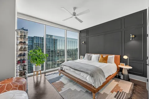 a bedroom with a large bed and a potted plant