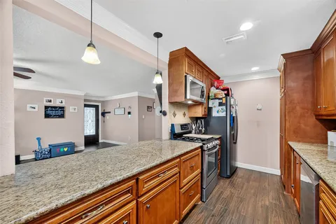 a kitchen with stainless steel appliances granite countertop sink stove top oven and refrigerator