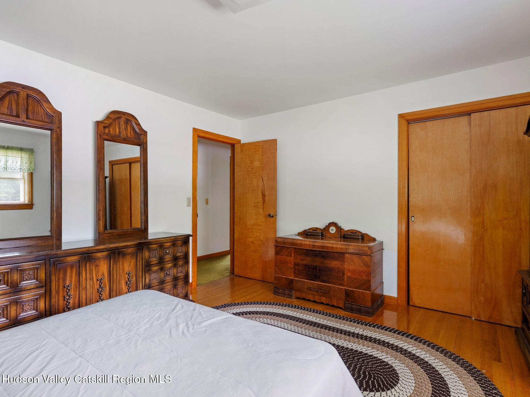 104 New Paltz Road Highland, NY 12528 - Photo 19 of 43 a bedroom with two beds and a large mirror next to a window