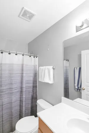 a bathroom with a sink a toilet and shower curtain