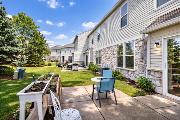 a view of a house with backyard sitting area and garden