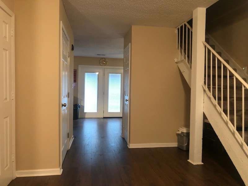a view of a hallway with wooden floor and staircase