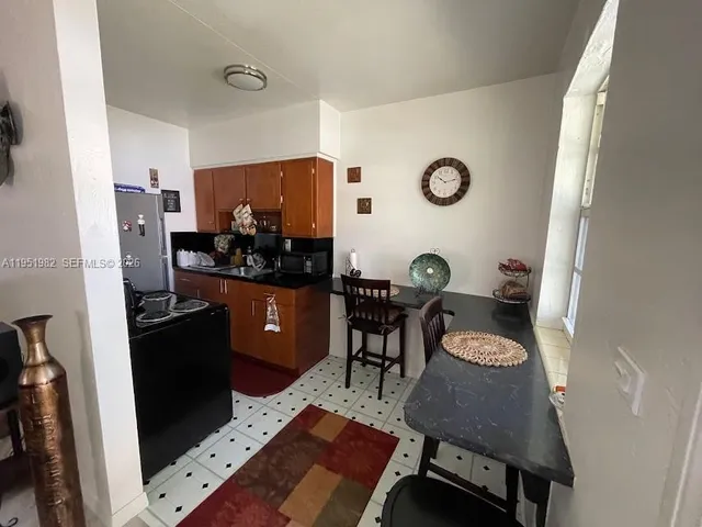 a kitchen with stainless steel appliances granite countertop a refrigerator sink stove and cabinets