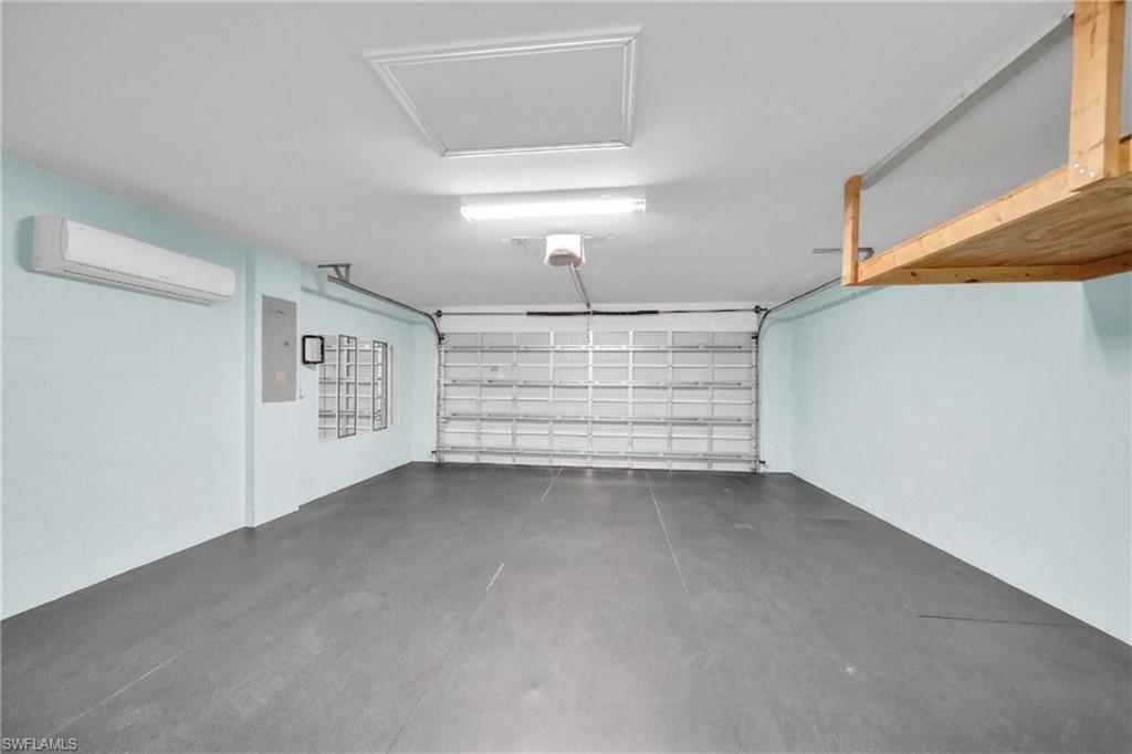 175 Shadowview Court Lehigh Acres, FL 33974 - Photo 16 of 39 Garage featuring a wall mounted mini split and electric panel