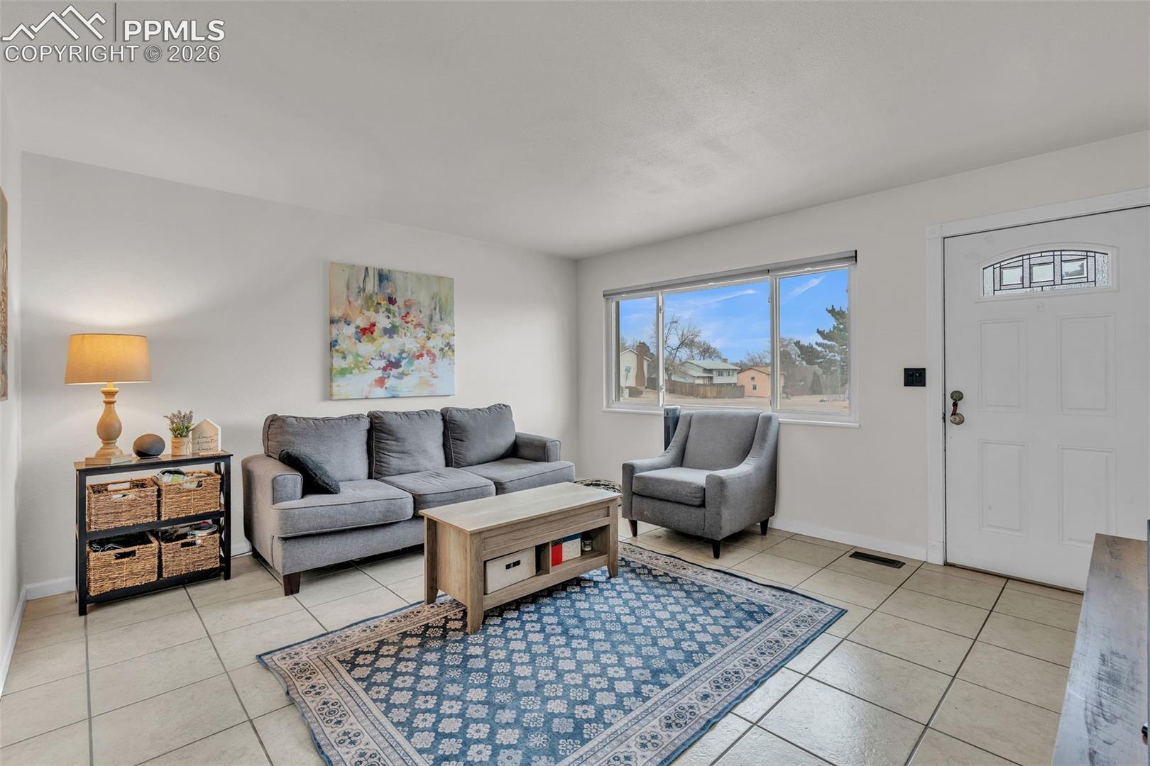 1498 Peterson Road Colorado Springs, CO 80915 - Photo 7 of 44 Living area featuring light tile patterned flooring and baseboards