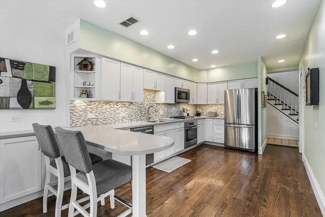 a kitchen with stainless steel appliances a stove sink microwave and cabinets