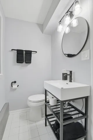 a bathroom with a toilet sink and mirror