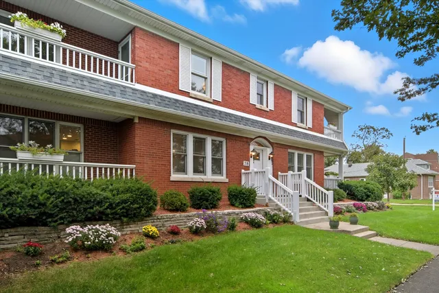 a aerial view of a brick house next to a yard