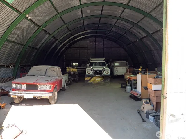 a view of a wooden house with a yard and large tree