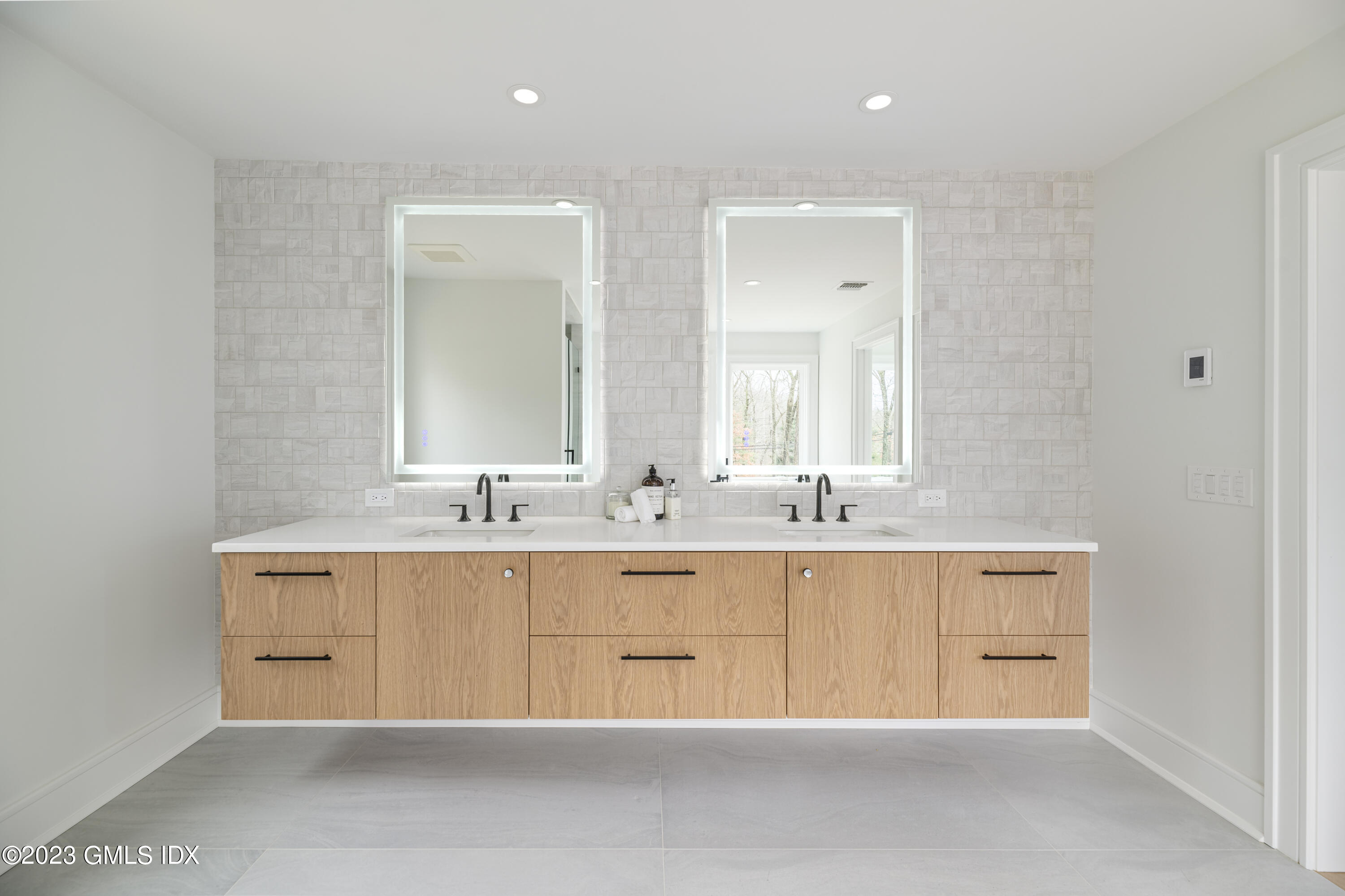 261 Cognewaugh Road Cos Cob, CT 06807 - Photo 20 of 38 a bathroom with double vanity and a mirror