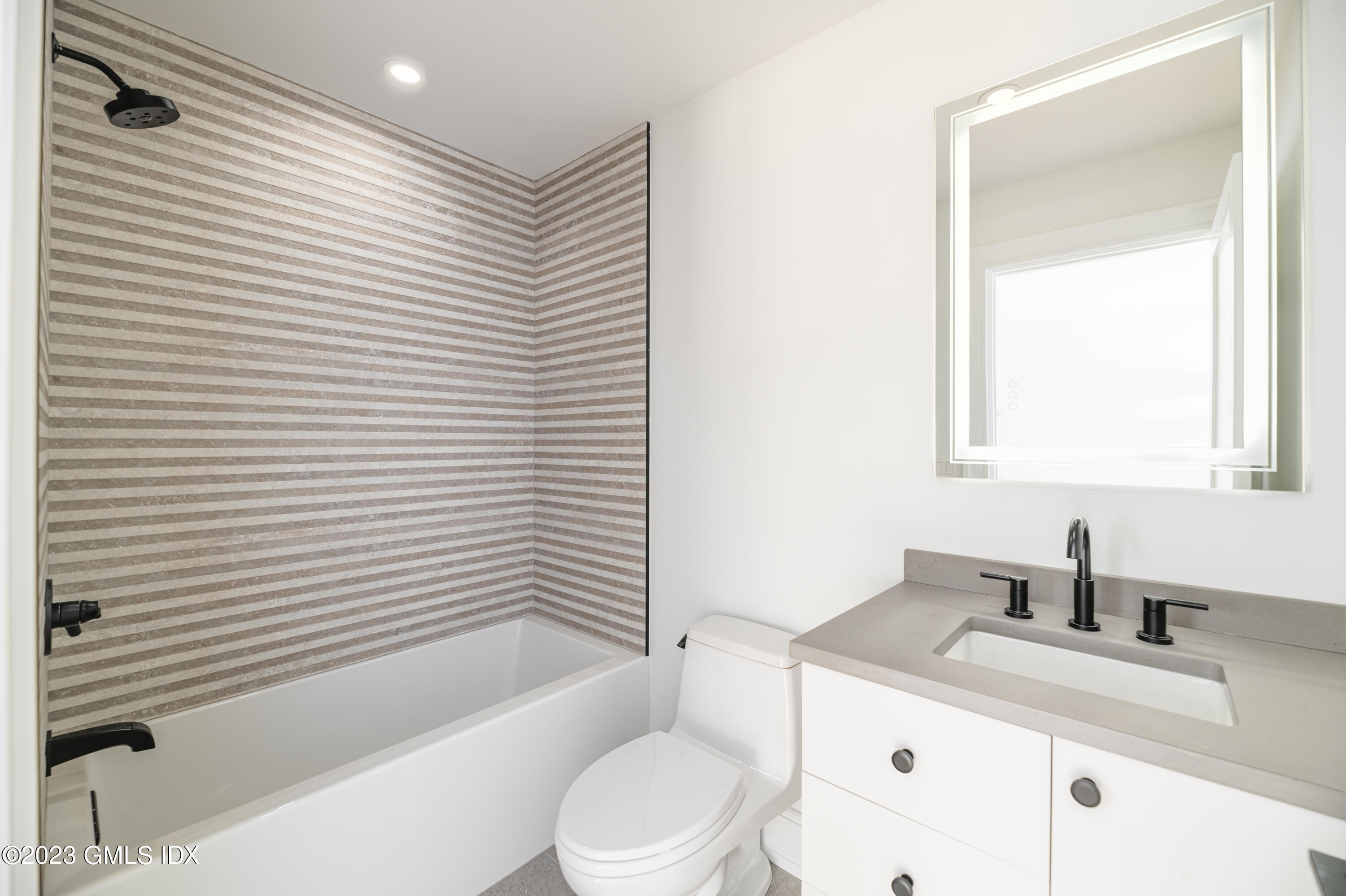 261 Cognewaugh Road Cos Cob, CT 06807 - Photo 27 of 38 a bathroom with a granite countertop sink toilet and shower