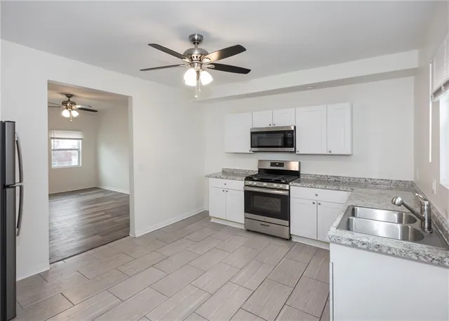 a kitchen with granite countertop a refrigerator and a sink
