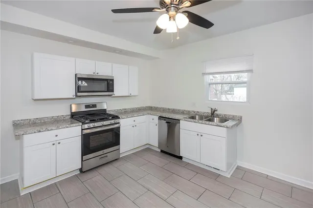 a kitchen with a sink stove and microwave