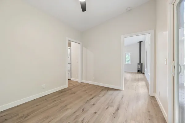 an empty room with wooden floor and mirror