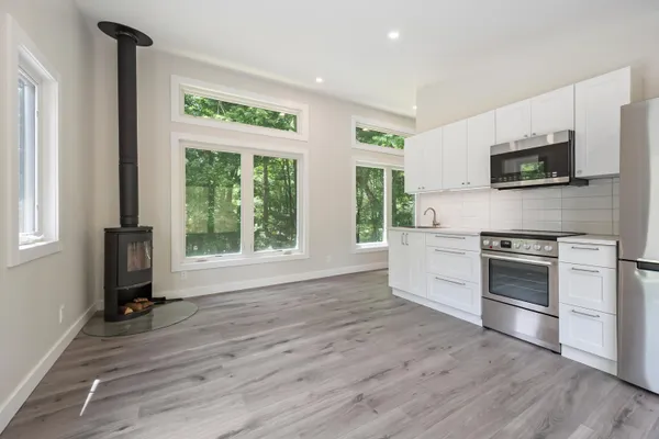 a kitchen with stainless steel appliances a stove top oven a sink and a microwave