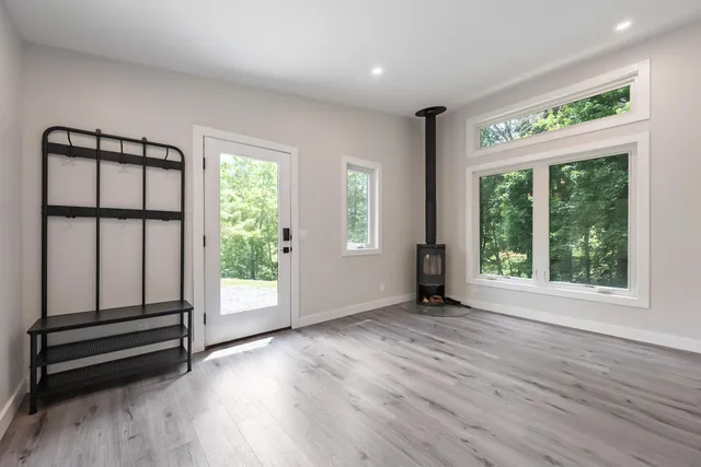 an empty room with wooden floor and windows