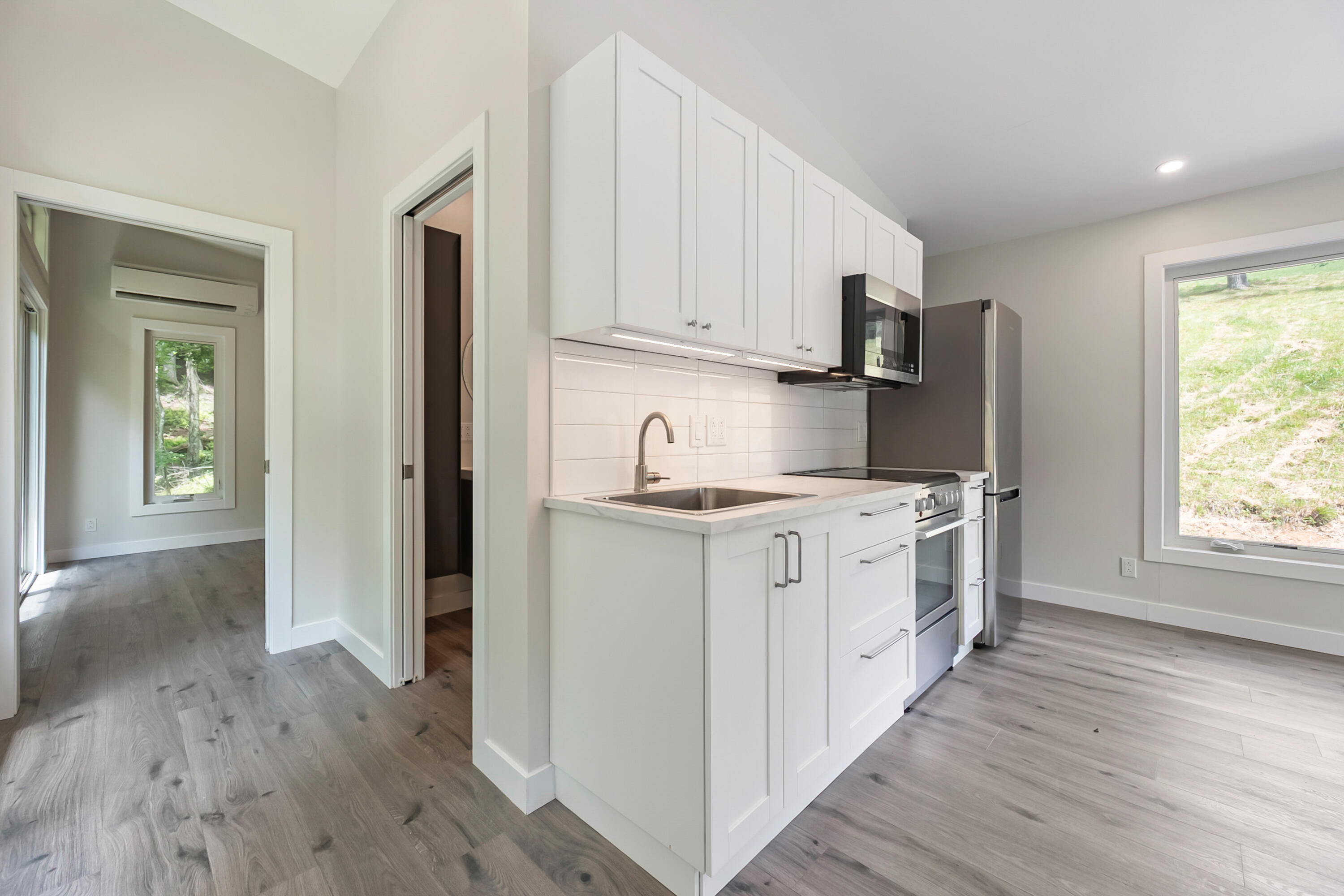 133 Wonder Way Northeast Pilot, VA 24138 - Photo 10 of 57 a kitchen with white cabinets and wooden floor