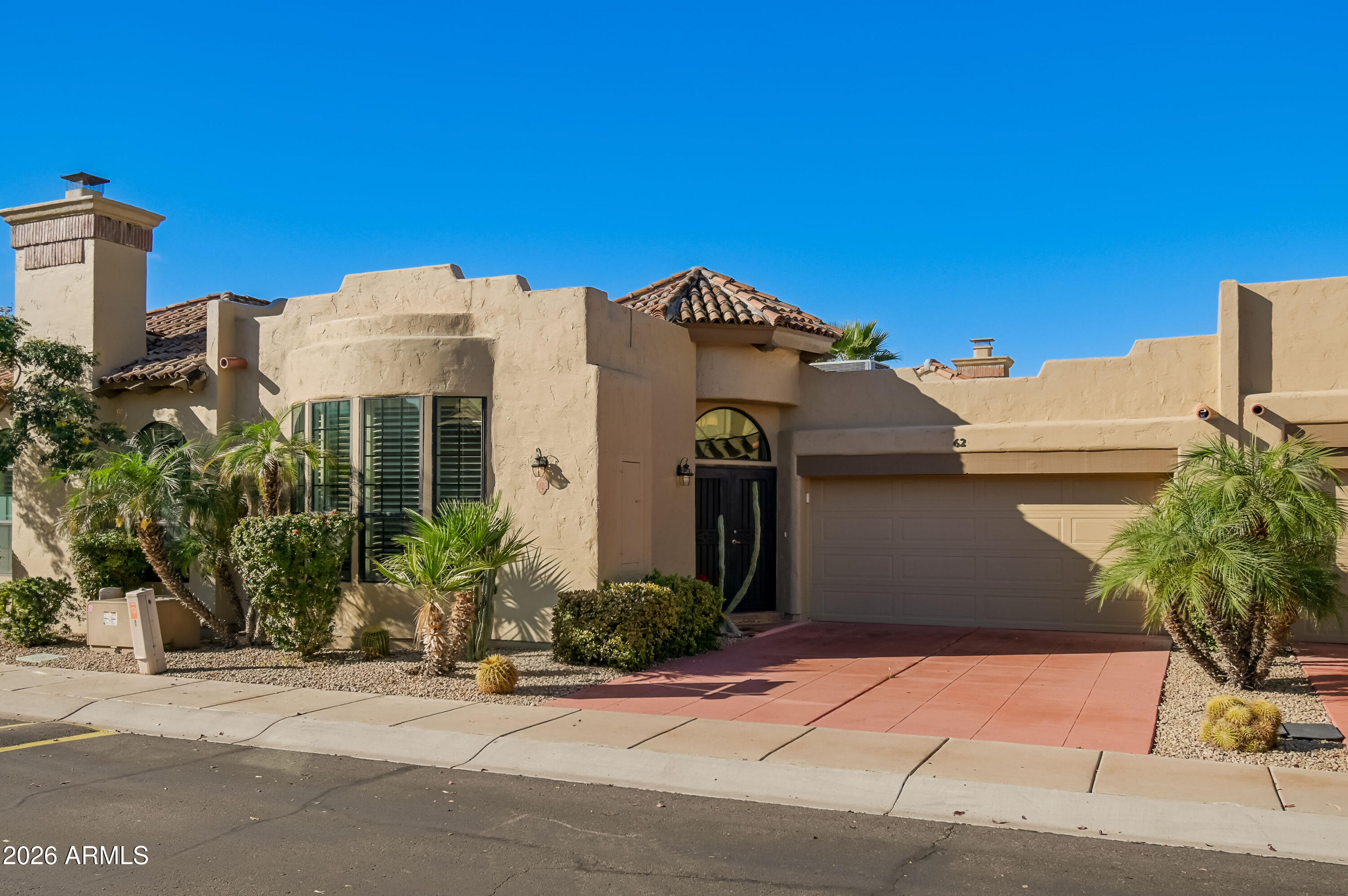 7955 East Chaparral Road, Unit 62 Scottsdale, AZ 85250 - Photo 4 of 38 a front view of a house with a yard