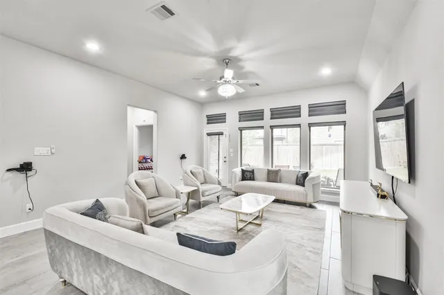 a living room with furniture and large windows