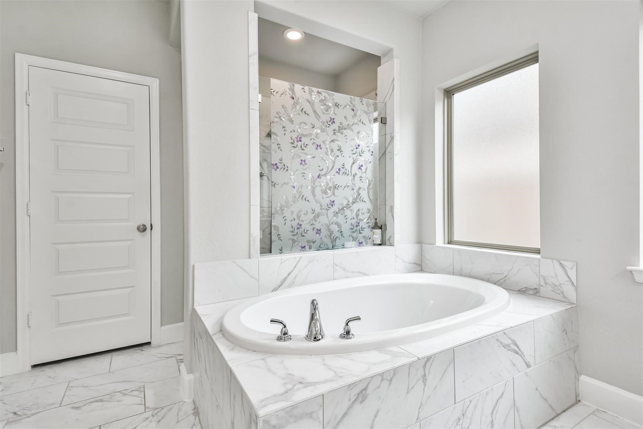 15018 Concho River Way Cypress, TX 77433 - Photo 22 of 34 a white bath tub sitting in a bathroom near a bathroom