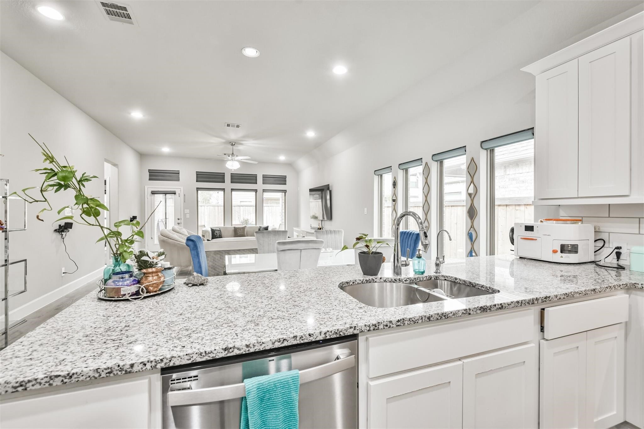 15018 Concho River Way Cypress, TX 77433 - Photo 10 of 34 a kitchen with sink stove and white cabinets with wooden floor