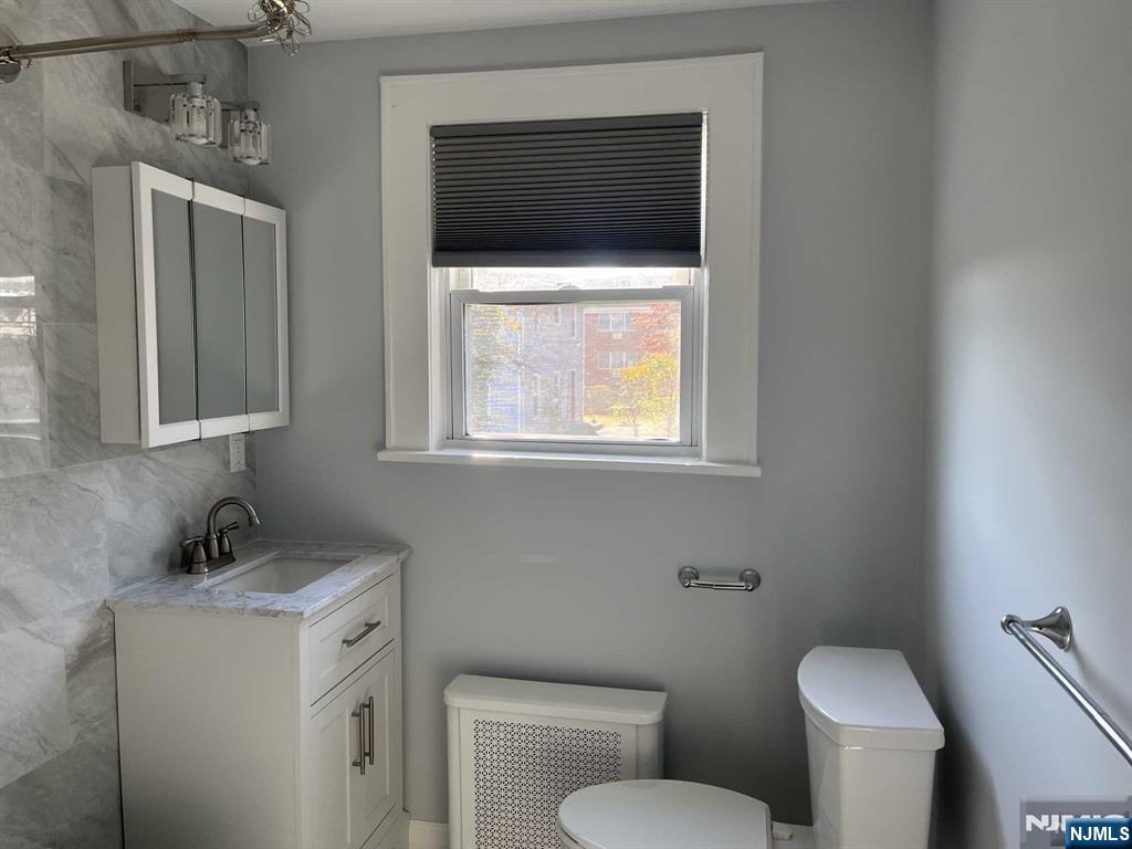 212 Walton Street, Unit 2 Ridgewood, NJ 07450 - Photo 13 of 27 a bathroom with a toilet sink and mirror