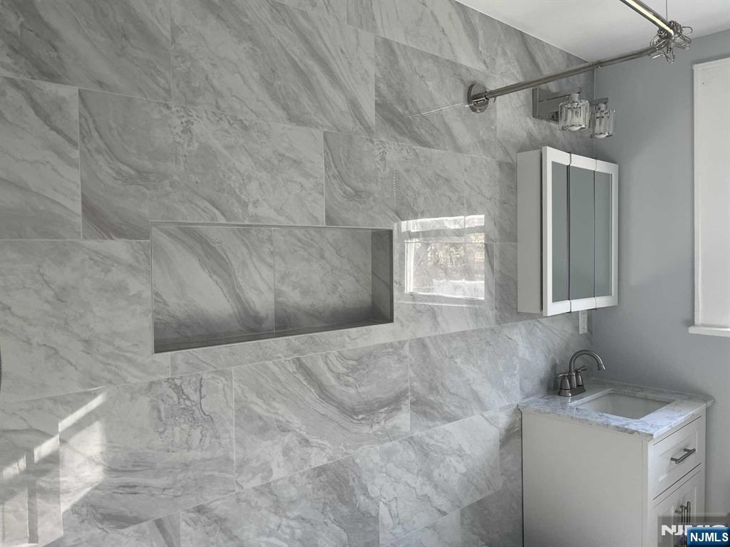 212 Walton Street, Unit 2 Ridgewood, NJ 07450 - Photo 14 of 27 a bathroom with a granite countertop sink a mirror and a shower
