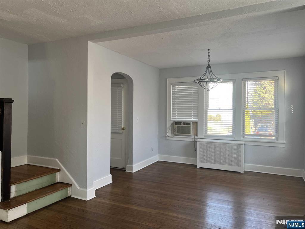 212 Walton Street, Unit 2 Ridgewood, NJ 07450 - Photo 9 of 27 an empty room with wooden floor chandelier and windows
