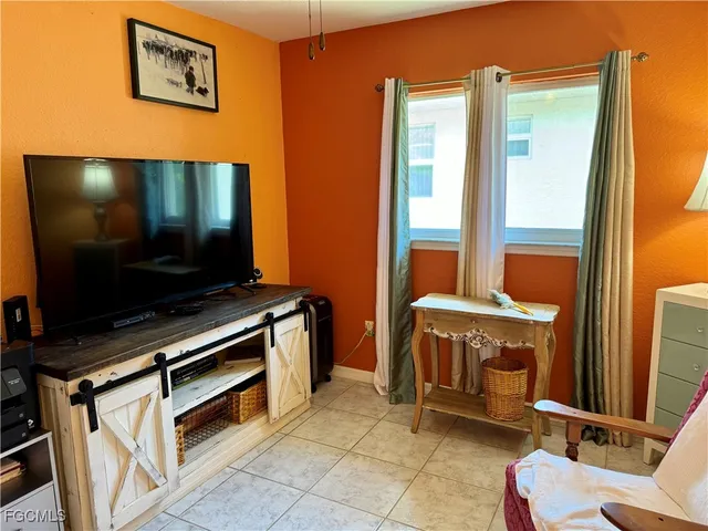 a living room with a flat screen tv and a refrigerator