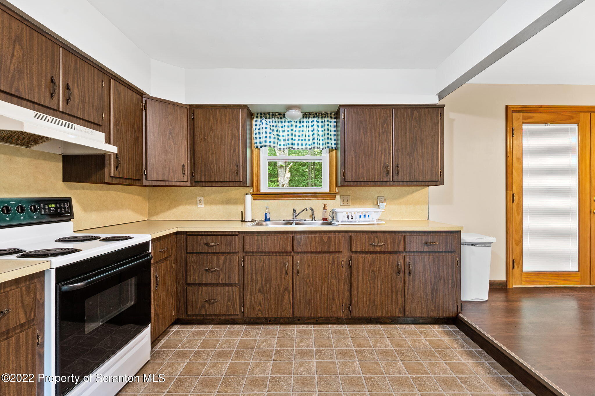 199 Spring Hill Road Moscow, PA 18444 - Photo 12 of 33 a kitchen with stainless steel appliances granite countertop wooden cabinets a stove a sink and a window