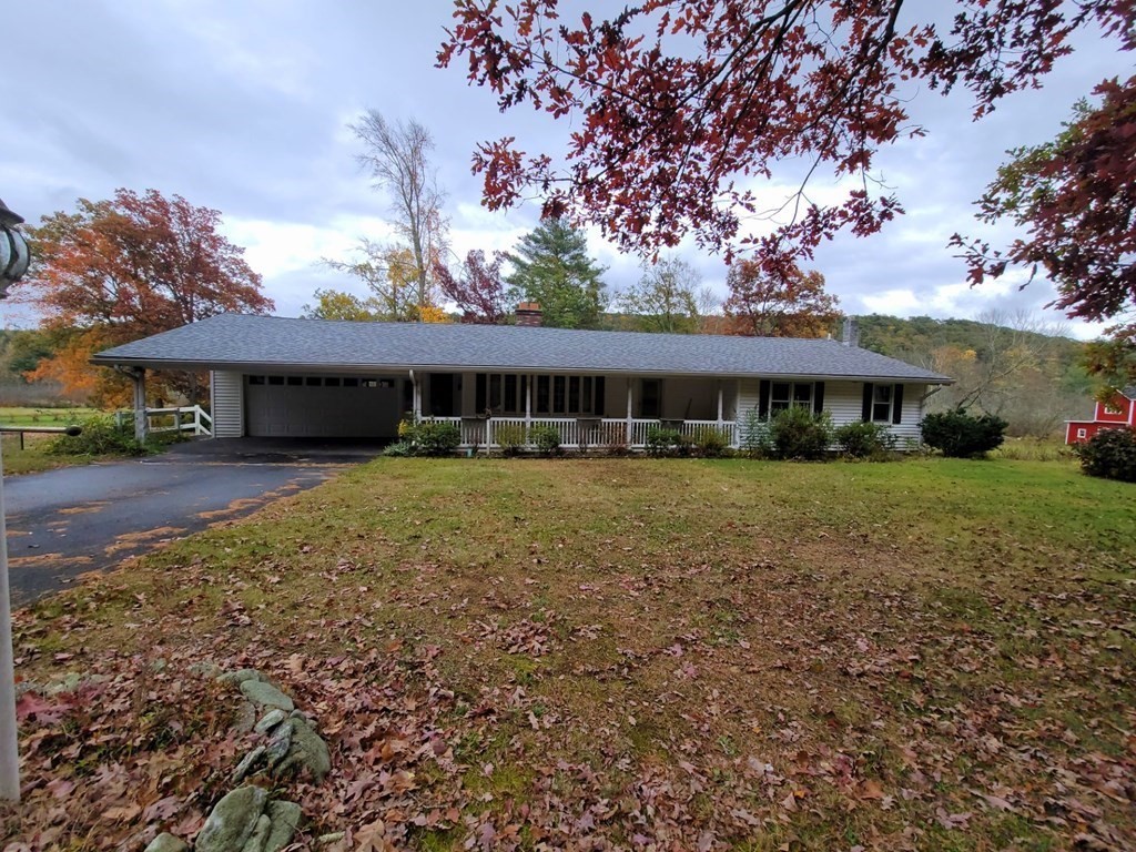 73 Hollow Road Brimfield, MA 01010 - Photo 1 of 23 a view of a white house with a yard plants and large tree