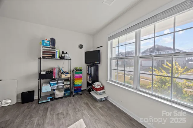 a living room with hard wood floors and a book shelf