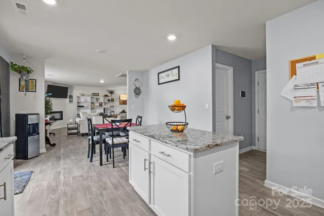 a kitchen with a sink white cabinets and chairs