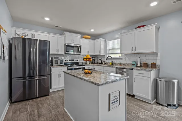 a living room with furniture a flat screen tv and a table