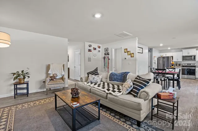 a living room with furniture a flat screen tv and a window