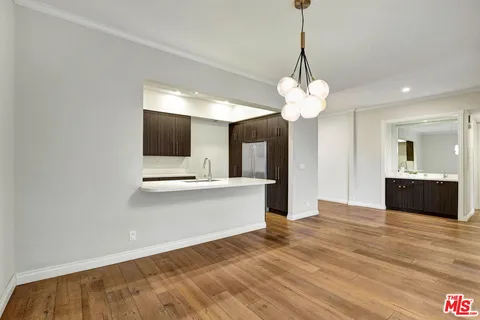 a view of a kitchen with wooden floor and a chandelier